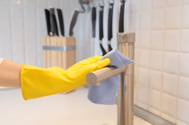 描述: Closeup of female hand in gloves cleaning the kitchen tap Free Photo