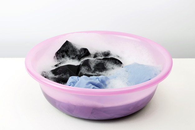 描述: Clothes washed with a basin with soap bubbles on white background Premium Photo